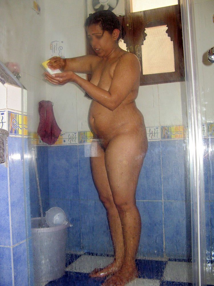 Mature woman standing nude in bathroom